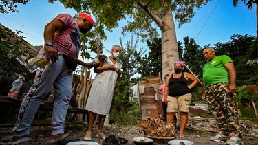 Babalawo Abel Ramírez (izq.) realiza una ceremonia yoruba -grupo étnico del África subsahariana- para alimentar a la Tierra junto a familiares y ahijados en La Habana, el 20 de diciembre de 2021. El acceso a los alimentos es un problema de columna vertebral en Cuba. Mientras el parlamento discute cómo producir más, los creyentes yorubas hacen ofrendas a la Madre Tierra en busca de abundancia y salud.