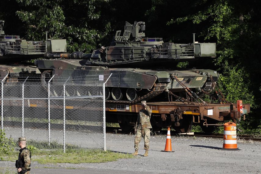 La policía militar camina cerca de los tanques Abrams sobre una plataforma en una terminal ferroviaria el lunes 1 de julio de 2019 en Washington.&nbsp;&nbsp;