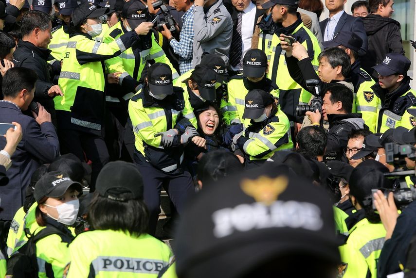 La policía detiene a estudiantes ante la Asamblea Nacional en Seúl, durante una manifestación convocada para protestar en contra de la próxima visita del presidente Donald Trump. 