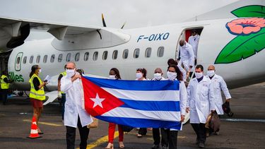 En esta foto de archivo tomada el 26 de junio de 2020, el médico jefe Abel Roberto Fuentes Santiesteban (izq.) Sostiene una bandera cubana cuando llega con una delegación de médicos cubanos al aeropuerto Martinica-Aime-Cesaire en Le Lamentin, cerca de Fort- de-France, en la isla caribeña francesa de Martinica, como parte de un programa de asistencia médica en medio de la pandemia de COVID-19 causada por el nuevo coronavirus.&nbsp; &nbsp;