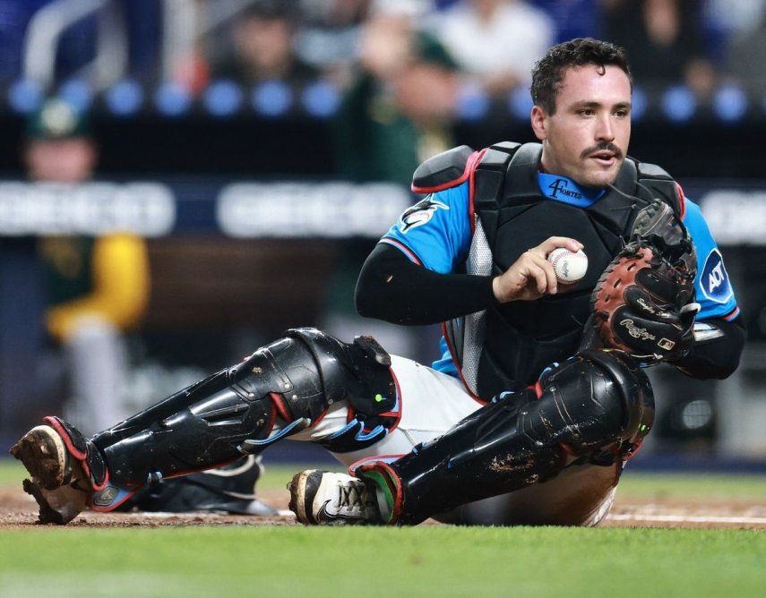 El receptor Nick Fortes, de los Marlins de Miami, sostiene la pelota tras retirar en el plato a Gio Urshela de los Atléticos, el 4 de mayo de 2025.