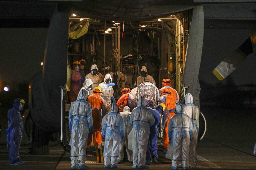 Trabajadores de la salud mueven a un paciente con COVID-19 para ser transportado de Santiago a la ciudad de Concepci&oacute;n para liberar espacio de unidades de cuidados intensivos en los hospitales capitalinos desde una base de la fuerza a&eacute;rea en Chile el martes 19 de mayo de 2020.