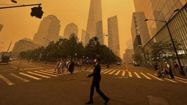 Peatones pasan junto al One World Trade Center (centro), en medio de la humareda causada por los incendios forestales en Canadá, el 7 de junio de 2023, en la Ciudad de Nueva York.&nbsp;