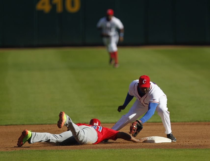 &nbsp;El jugador de Criollos de Caguas Jorge Padilla (izquierda) trata de alcanzar la base ante Alexander Ayala (derecha) de Alazanes