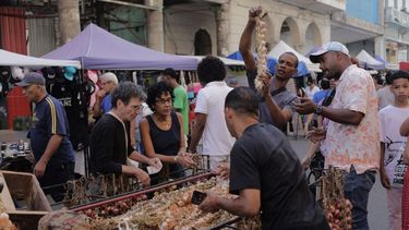 Clientes reunidos en torno a un carro de ajos en un mercado callejero en La Habana, Cuba, el sábado 16 de marzo de 2024. 