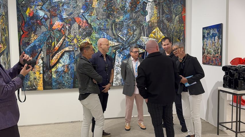 El artista Fredy Villamil, de espaldas, conversa con varias personas en el stand de Aldo Castillo Gallery, en Art Miami 2024.&nbsp;