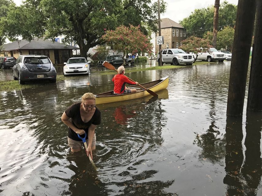 Varias personas realizan trabajos de limpieza después de una intensa tormenta en el vecindario Broadmoor de Nueva Orleans, el miércoles 10 de julio de 2019. ()