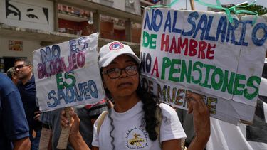 Una docente con carteles durante una protesta por mejores salarios y beneficios en Caracas, Venezuela, el lunes 18 de septiembre de 2023. 