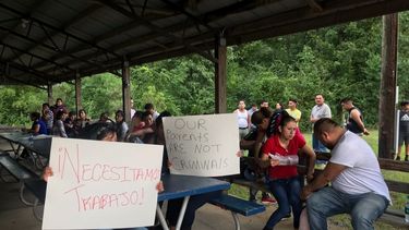 Trabajadores de PH Foods y simpatizantes de su causa sostienen carteles que dicen, &iexcl;Necesitamos trabajo! y Nuestros padres no son criminales.