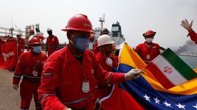 Un trabajador petrolero venezolano que sostiene una peque&ntilde;a bandera de Ir&aacute;n asiste a una ceremonia el lunes 25 de mayo de 2020 por la llegada del buque iran&iacute; Fortune, en la refiner&iacute;a El Palito cerca de Puerto Cabello, Venezuela