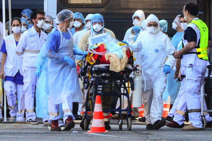 Trabajadores de la salud trasladan de un tren de alta velocidad hacia un hospital a un paciente infectado con el COVID-19, París, Francia.
