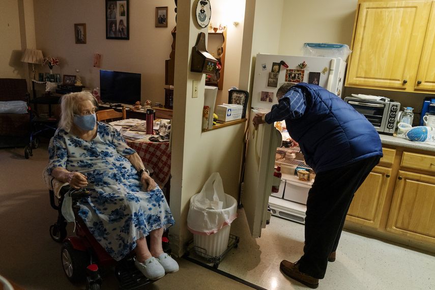 Jim Stotler, del programa Meals on Wheels, acomoda en la nevera la comida que le acaba de llevar a Phyllis Antonelli, mujer de 90 años que vive en Pawtucket, Rhode Island, el 20 de noviembre del 2020.&nbsp;