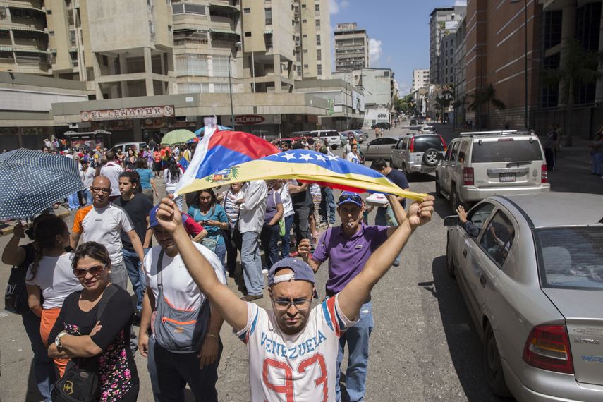 Un grupo de personas participa en la consulta opositora de hoy, domingo 16 de julio de 2017, en el centro de Caracas.