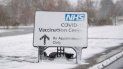 Un letrero cubierto de nieve dirige a las personas al centro de vacunación contra el COVID-19 en el estadio comunitario Jobserve en Colchester, Inglaterra, el domingo 7 de febrero de 2021. 