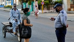 Un agente de la polic&iacute;a del r&eacute;gimen verfica a ciudadanos cubanos en las calles de La Habana, el 4 de abril de 2020.