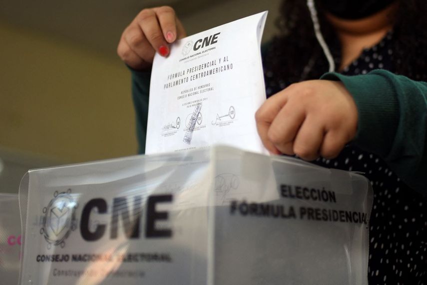 Ciudadana hondureña deposita su voto en la urna el domingo 28 de noviembre de 2021.