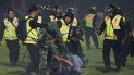 Agentes de seguridad detienen a un aficionado durante una serie de trifulcas en un partido de fútbol, el sábado 1 de octubre de 2022, en Malang, Indonesia 