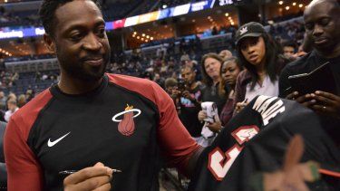 El guardia del Heat de Miami, Dwyane Wade, firma autógrafos antes de un partido de baloncesto de la NBA contra los Grizzlies de Memphis, el viernes 14 de diciembre de 2018.
