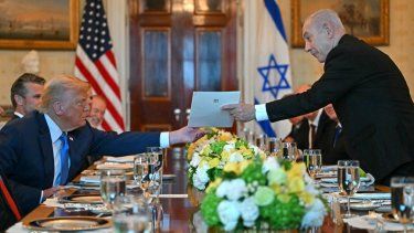 El primer ministro israelí, Benjamin Netanyahu (der.), entrega una carta al presidente estadounidense, Donald Trump, durante su reunión en la Sala Azul de la Casa Blanca en Washington, D.C., el 7 de julio de 2025.&nbsp;