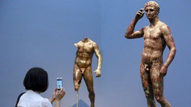 La reportera Sookee Chung toma una foto a una escultura llamada Juventud victoriosa, hecha entre el 300 aC y el 100 aC, en el Museo J. Paul Getty en Los Ángeles, el 27 de julio de 2015. &nbsp;