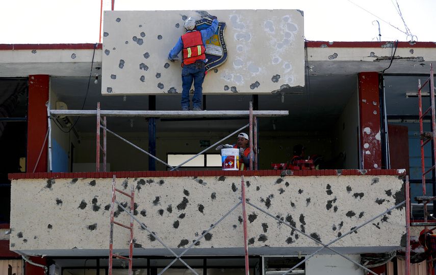 Trabajadores reparando la fachada del ayuntamiento, lleno de agujeros de bala, en Villa Uni&oacute;n, M&eacute;xico, el lunes 2 de diciembre de 2019.&nbsp;