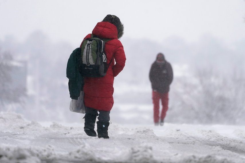 La gente camina sobre una calle nevada durante la tormenta invernal que azota a la región en Kansas City, Misuri, EE.UU., el martes 9 de enero del 2024.