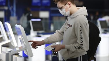 El estudiante universitario en Nueva York Hector Medrano, de Los &Aacute;ngeles, factura en su vuelo con una pantalla t&aacute;ctil, el s&aacute;bado 14 de marzo de 2020 en la terminal de jetBlue, en el aeropuerto John F. Kennedy International en Nueva York.&nbsp;