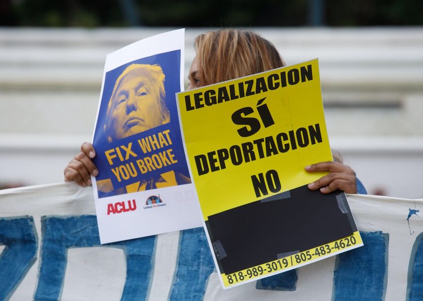 Fotografia de archivo de una mujer que sostiene un cartel en contra de la deportación de inmigrantes en EEUU.