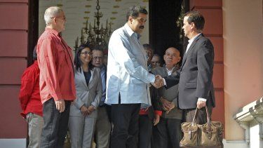 Nicolás Maduro le da la mano a los jefes negociadores del gobierno de Colombia, Frank Pearl, junto al guerrillero de izquierda ELN del país, Eliecer Herlinton Chamorro Acosta, alias Antonio García (2-L), tras reunión en la presidencia de Miraflores, en Caracas, el 30 de marzo de 2016.