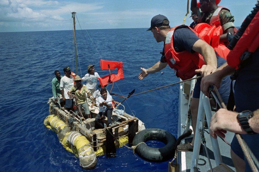 Un miembro de la tripulación del guardacostas estadounidense Maui lanza un chaleco salvavidas a un grupo de balseros cubanos el 4 de septiembre de 1994. El grupo fue avistado a unas 15 millas de la costa cubana en el Estrecho de Florida.&nbsp;