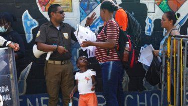 Un funcionario comprueba los documentos de migrantes que esperan para regularizar su situación en México frente al Instituto Nacional de Migración de Tapachula, estado de Chiapas. Migrar es pagar, aunque no siempre sea a un traficante.