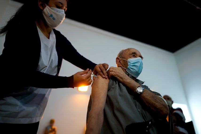 Una enfermera administra una dosis de la vacuna Sputnik V COVID-19 a un anciano en el Parque Tecnopolis, que ha sido reutilizado como centro de vacunas, en Buenos Aires, Argentina, el jueves 15 de abril de 2021. En medio de un proceso de vacunación que marcha más lento de lo que desean las autoridades, el presidente argentino Alberto Fernández ratifica las más recientes restricciones para atajar el incremento de contagios.