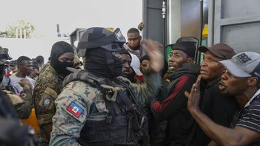 Agentes de la policía tratan de controlar a una multitud que intenta obtener combustible en una gasolinera de Puerto Príncipe, Haití, el jueves 4 de noviembre de 2021.&nbsp;
