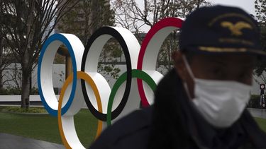Un guardia de seguridad camina frente a los anillos ol&iacute;mpicos cerca del Estadio Nacional de Tokio, el lunes 23 de marzo de 2020.&nbsp;