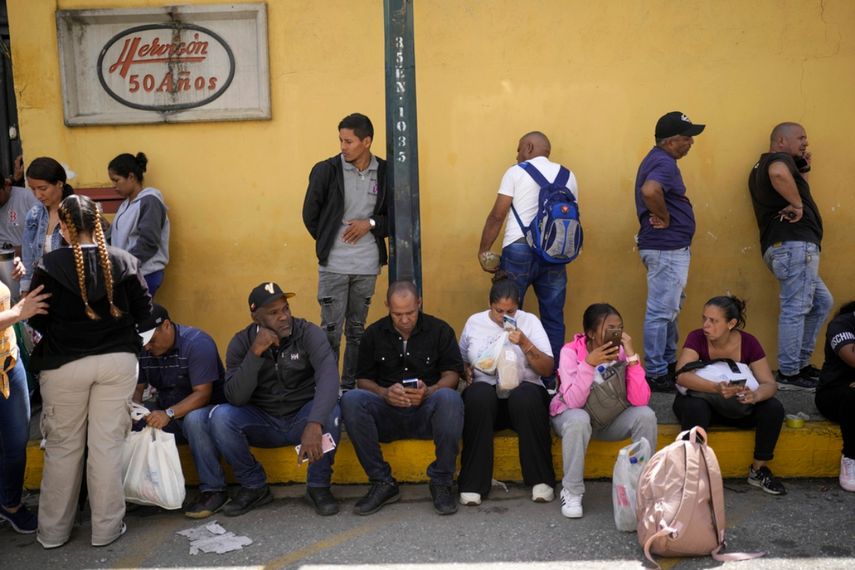 Familiares de personas detenidas durante las protestas contra Nicolás Maduro esperan noticias de sus seres queridos en las afueras de un centro de detención policial en Caracas.  