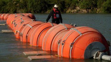 Una persona en kayak pasa al lado de boyas instaladas como barrera en el Río Grande (o Bravo), el 1 de agosto de 2023, en Eagle Pass, Texas.&nbsp;