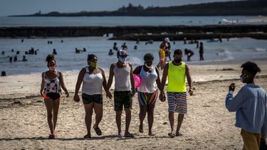 Personas que usan m&aacute;scaras como precauci&oacute;n contra la propagaci&oacute;n del nuevo coronavirus caminan en la playa en La Habana, Cuba, el domingo 11 de octubre de 2020.&nbsp;