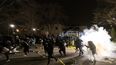 Gente corriendo mientras la policía intenta dispersar a la gente ante la comisaría de Brooklyn Center, en la noche del domingo 11 de abril de 2021 en Brooklyn Center, Minnesota. La familia de Daunte Wright, de 20 años, dijo a la gente que el joven había sido baleado por la policía antes de volver a subir a su auto para tratar de huir. El vehículo se estrelló unas pocas cuadras más allá. La muerte de Wright se certificó más tarde, según la familia.&nbsp;
