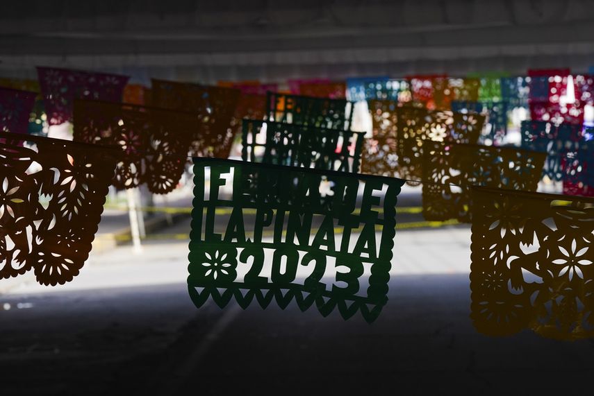 Papel picado anuncia la feria de la piñata en Acolman, al norte de Ciudad de México, el miércoles 13 de diciembre de 2023. Los abuelos mexicanos recuerdan aún épocas en las que las piñatas se hacían con vasijas de barro cubiertas con papel y rellenas de azúcar, frutas y cacahuates. Pero la tradición ha avanzado con los años y ahora hay piñatas de muchas figuras.
