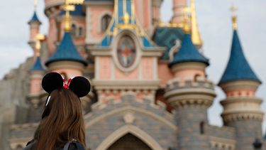 Visitante con las emblemáticas orejas de Mickey y Minnie Mouse observa al castillo inspirado en la Bella Durmiente en el Parque Disneyland París, en Marne-la-Vallée, al este de París, el 16 de octubre de 2023.&nbsp;