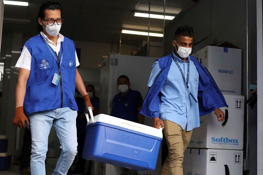Trabajadores del Ministerio de Salud cargan hieleras con vacunas para el COVID-19 que el gobierno de El Salvador donó a Honduras mientras cargan camiones que partirán de San Salvador, El Salvador, el jueves 13 de mayo de 2021.