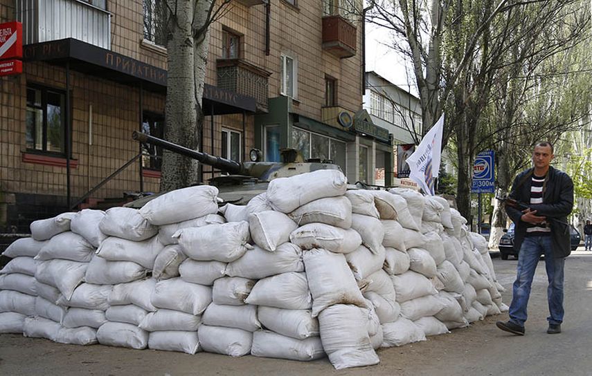 Un individuo armado prorruso patrulla una calle en el centro de Sloviansk, en el este de Ucrania, el miércoles 23 de abril de 2014. (AP)