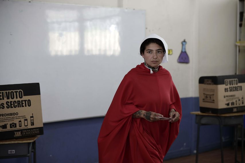 Un activista del colectivo feminista Somos Nuestras, vestida con un traje de la serie de televisión The Handmaids Tales, llega a votar hoy, domingo 1 de abril de 2018, durante la segunda ronda de las elecciones presidenciales, en San José (Costa&nbsp;Rica). E&nbsp;