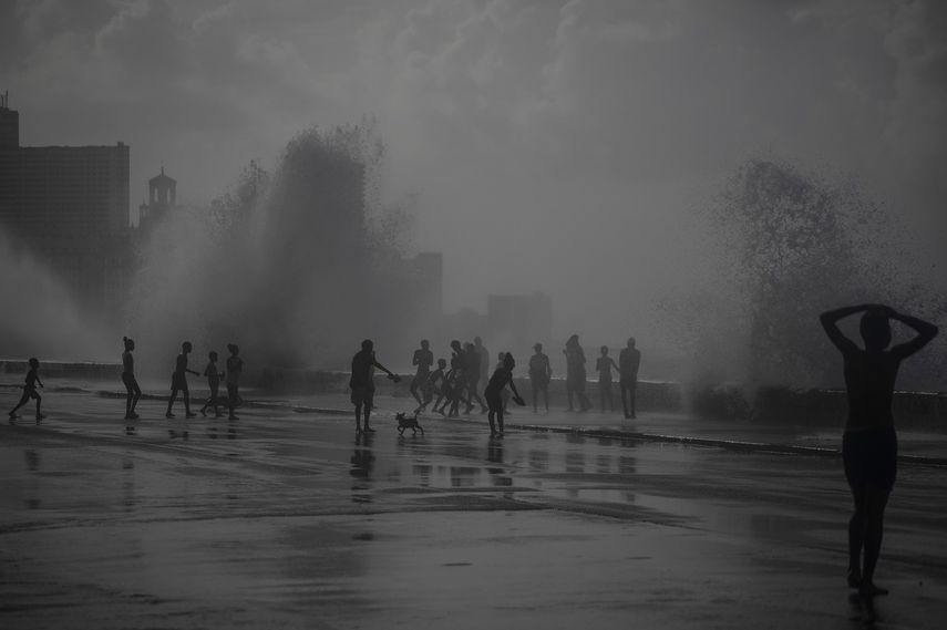 La gente juega en las olas que rompen en el Malecón, después del huracán Ian en La Habana, Cuba, el miércoles 28 de septiembre de 2022.&nbsp;