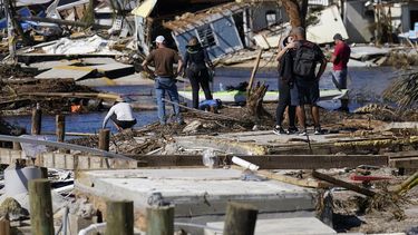 Gente de pie en el puente destruido a Pine Island mientras contemplan los daños causados por el huracán Ian en Matlacha, Florida, el domingo 2 de octubre de 2022. El único puente a la isla estaba muy dañado y sólo se podía acceder por mar o aire.&nbsp;