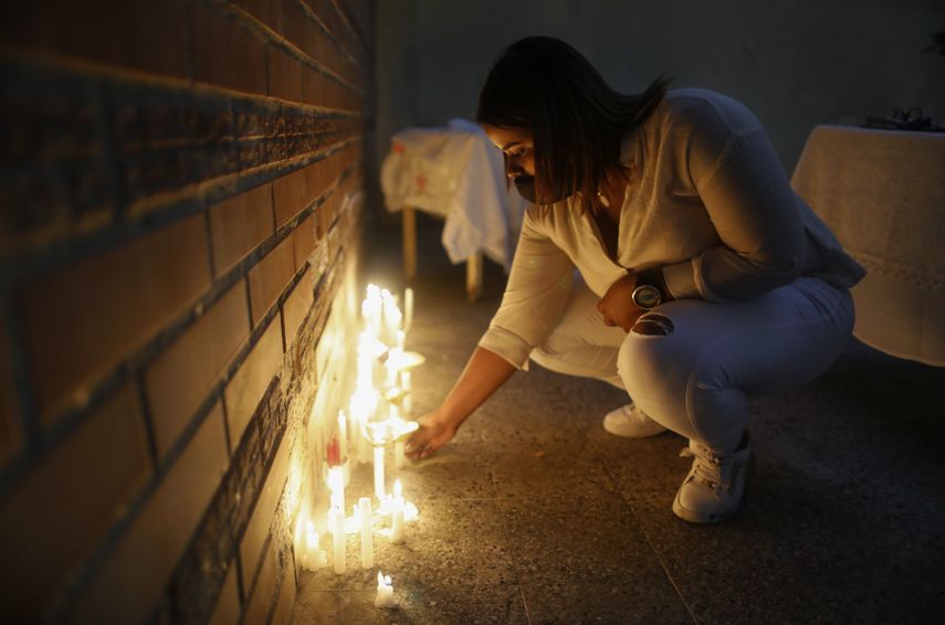 Gray Zapata coloca una vela encendida en Caracas, Venezuela, el miércoles 16 de diciembre de 2020, durante una vigilia por las víctimas encontradas ahogadas el fin de semana pasado. Dos embarcaciones que transportaban a unos 40 migrantes venezolanos desaparecieron hace casi dos semanas, y se dirigían a la cercana nación caribeña de Trinidad y Tobago para visitar a familiares o comprar bienes no disponibles en Venezuela dada la escasez de alimentos en su país, según un residente de Güiria, quien pidió que se ocultara su nombre por temor a represalias por parte de las autoridades.
