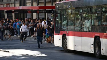 La gente espera mientras asiste en una parada de autobús durante un apagón en Santiago el 25 de febrero de 2025.