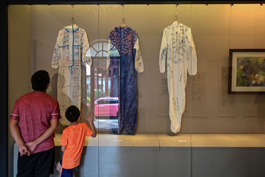 Un hombre y un ni&ntilde;o observan los trajes de&nbsp; los sanitarios que lucharon en la pandemia que son expuestos en el museo de la Revoluci&oacute;n.&nbsp;