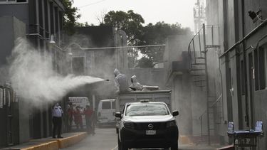 Trabajadores de la ciudad con equipos de protecci&oacute;n desinfectan un &aacute;rea afuera de un hospital p&uacute;blico donde el personal protesta por la falta de equipo de protecci&oacute;n contra el nuevo coronavirus en la Ciudad de M&eacute;xico, el martes 21 de abril de 2020.
