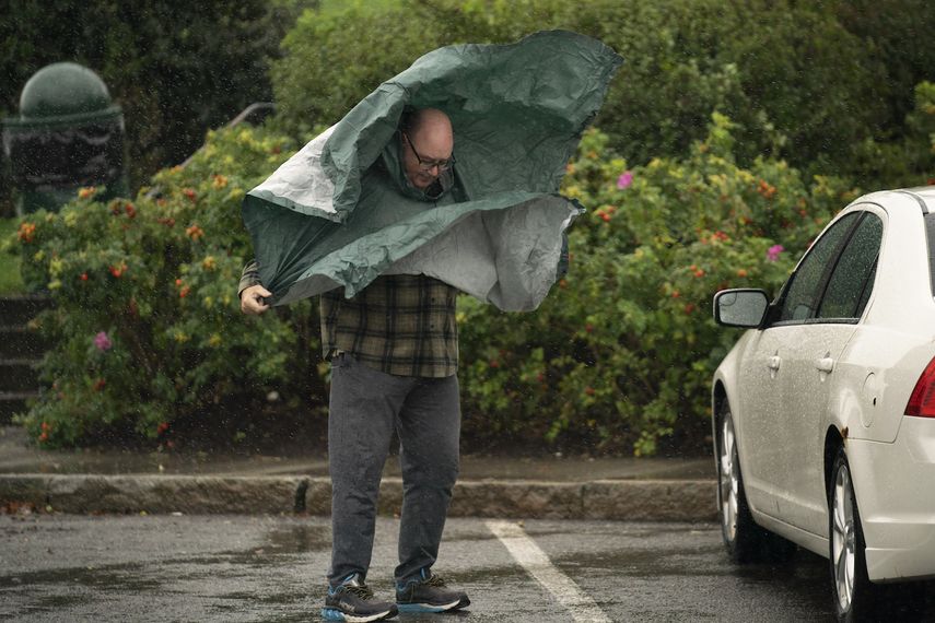 Un turista lidia con los fuertes vientos a la llegada de la tormenta Lee a la región, el sábado 16 de septiembre de 2023, en Bar Harbor, Maine.